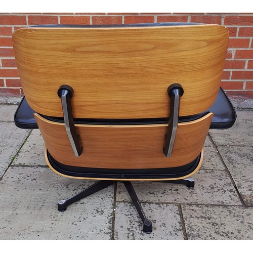 75 - An Eames style armchair covered in black leather. 82cm h x 85cm w x 72cm d.