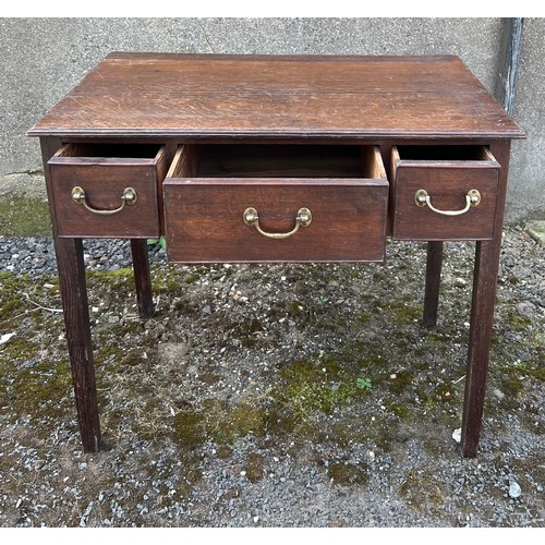 84 - An early 19thC three drawer oak lowboy with drop brass handles. 75cm w x 45cm d x 65cm h.