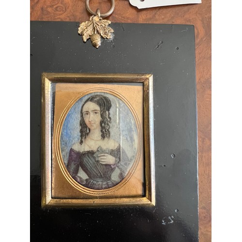 1264 - A 19thC miniature of a girl on ivory, in a purple dress and shoulder length hair, within a gilt bord... 