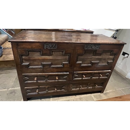 100 - An oak blanket box above four drawers with carved panels. IW 1703 carved into the top. New hinges to... 