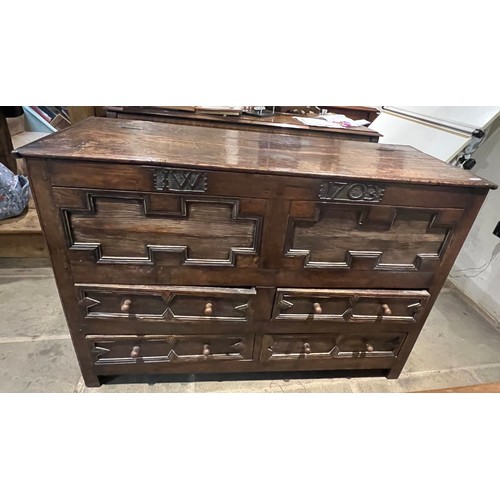 100 - An oak blanket box above four drawers with carved panels. IW 1703 carved into the top. New hinges to... 