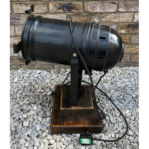 70B - A black vintage theatre lamp mounted on a wooden base. Approx 55cm h.