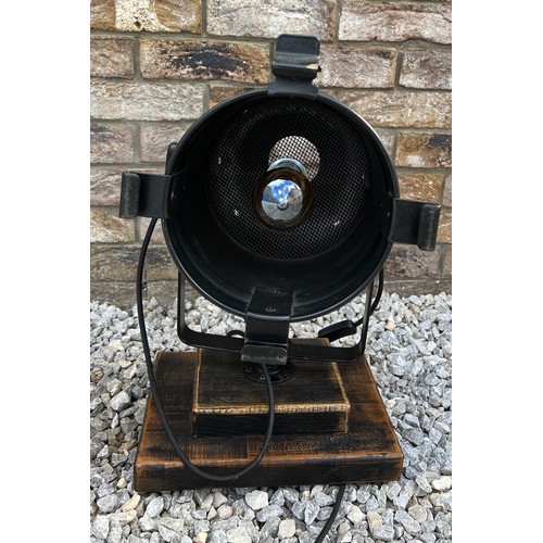 70B - A black vintage theatre lamp mounted on a wooden base. Approx 55cm h.