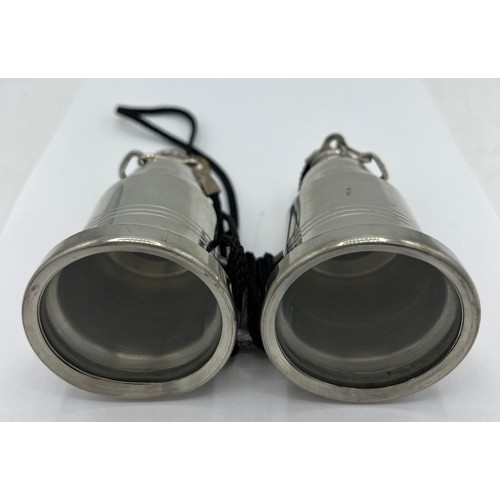 95A - A novelty pewter hip flask modelled as a pair of binoculars, each eye piece unscrewing to form two f... 