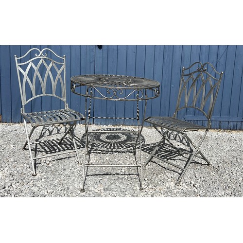 95C - A silvered cast steel garden table and two chairs. Table 75cm h x 68cm diameter.