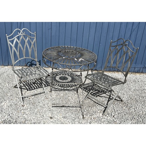 95C - A silvered cast steel garden table and two chairs. Table 75cm h x 68cm diameter.