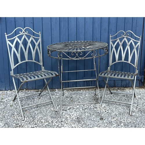 95C - A silvered cast steel garden table and two chairs. Table 75cm h x 68cm diameter.