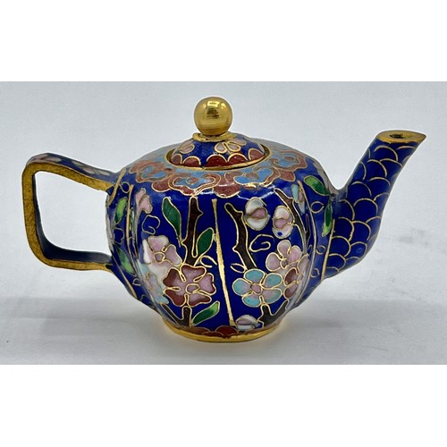 95B - A miniature cloisonn� teapot with floral decoration on blue ground. 5cm h x 8cm w.