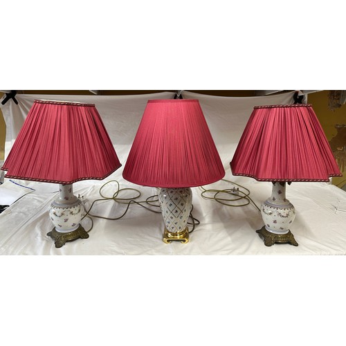 749A - Three ceramic table lamps with brass fittings, all with red shades. Two a matching pair.