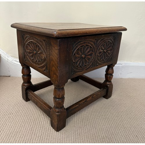 37 - A heavy oak stool with lift up lid and carving to the front and sides. 42.5w  x 33 d x39cm h.