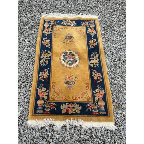 1241 - A mustard ground oriental style rug with central medallion.  94 x 152cm.