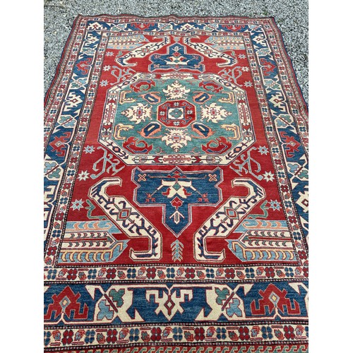 1242 - A large Caucasian rug, red, blue and cream ground. 199 x 281cm.