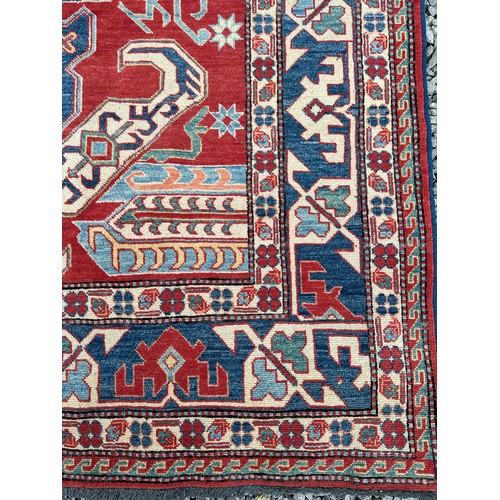 1242 - A large Caucasian rug, red, blue and cream ground. 199 x 281cm.