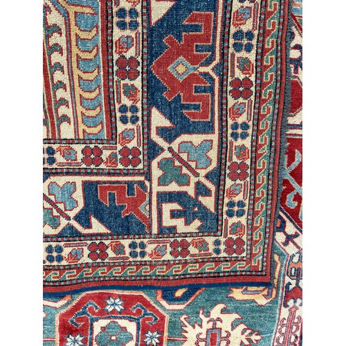 1242 - A large Caucasian rug, red, blue and cream ground. 199 x 281cm.