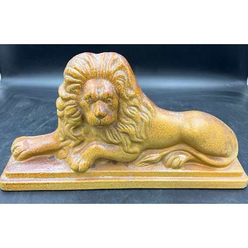 121 - A 19thC treacle glazed lion. 44cm w x 24cm h.