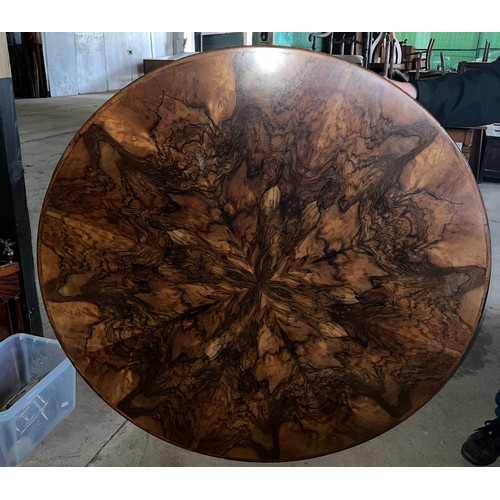 60 - A circular burr walnut dining table. 133cm d x 79cm h. The base with pull out mechanism but no extra... 