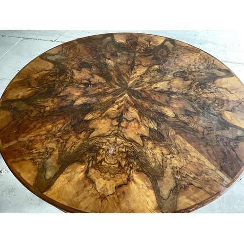 60 - A circular burr walnut dining table. 133cm d x 79cm h. The base with pull out mechanism but no extra... 