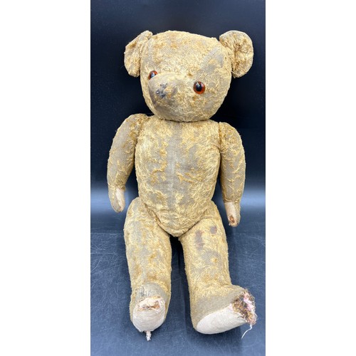 1066 - An early 20th century well loved straw filled teddy bear. Approximately 51cm high.