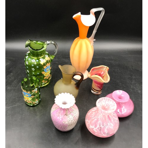 309 - An assortment of 15 pieces of glass to include jugs and vases in varying colours including a matchin... 