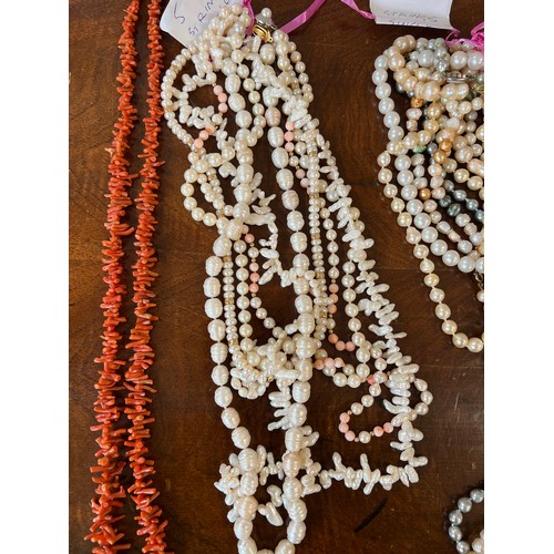 349 - A large quantity of pearl bead necklaces together with a coral necklace.