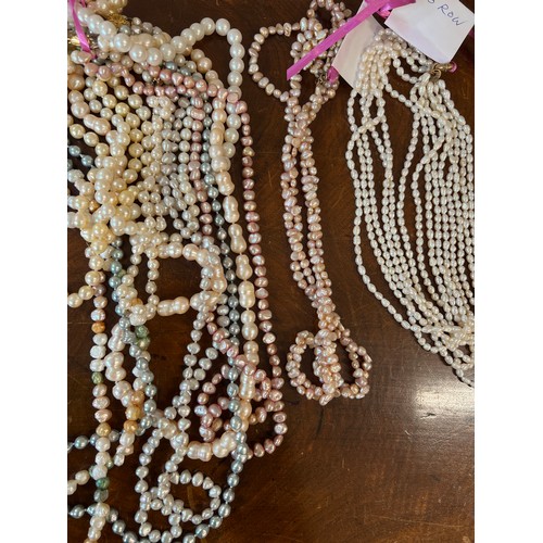 349 - A large quantity of pearl bead necklaces together with a coral necklace.