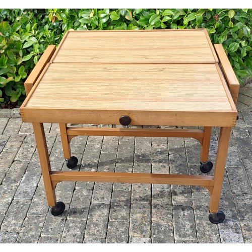 70 - A mid century tea trolley on castors and opening up to form a square topped  table. 74cm h x 78cm w ... 