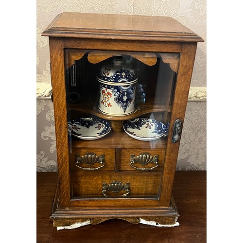 1340 - An Edwardian oak smokers cabinet with three internal drawers, tobacco jar, plates and pipe. 27cm w x... 