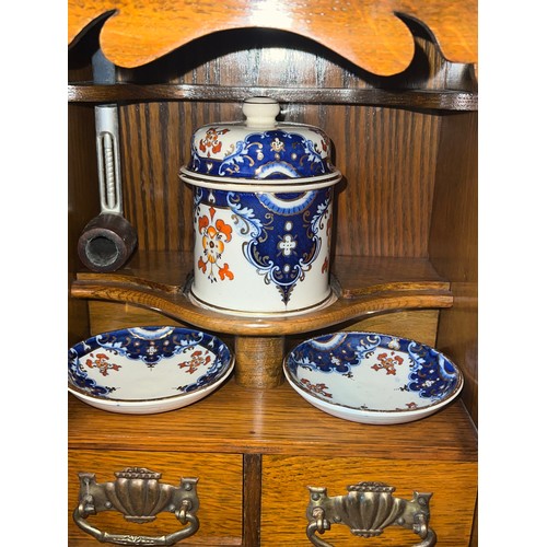 1340 - An Edwardian oak smokers cabinet with three internal drawers, tobacco jar, plates and pipe. 27cm w x... 