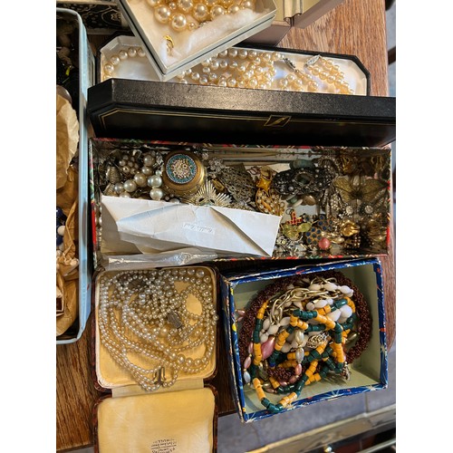 355 - A large quantity of vintage costume jewellery and boxes to include brooches, beads etc.