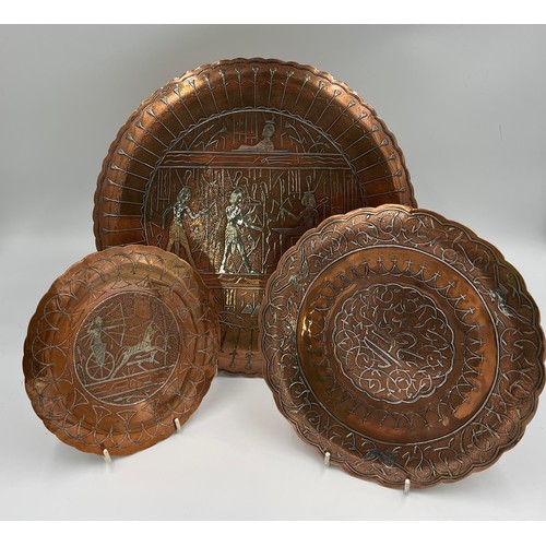 1188 - Three Egyptian copper and white metal wall plates, largest 35cm d.