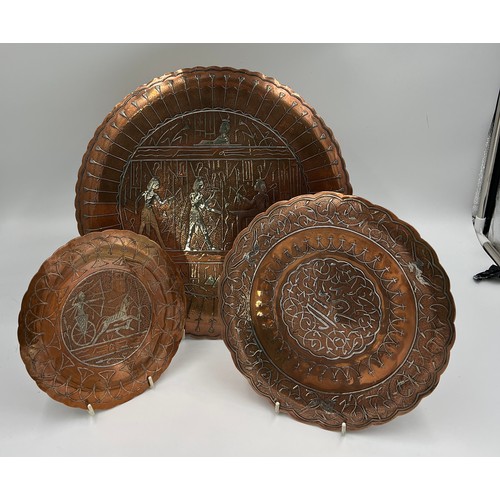 1188 - Three Egyptian copper and white metal wall plates, largest 35cm d.