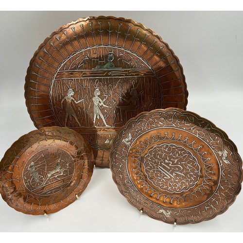 1188 - Three Egyptian copper and white metal wall plates, largest 35cm d.