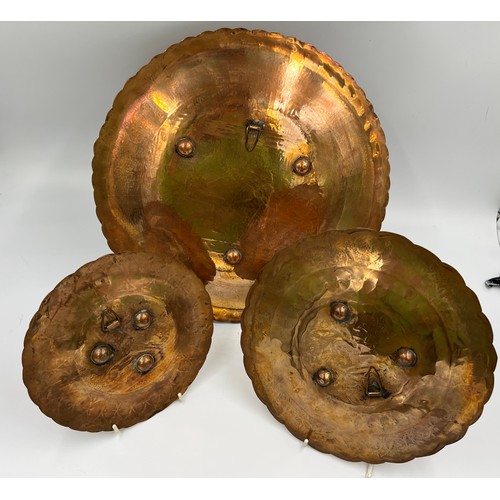 1188 - Three Egyptian copper and white metal wall plates, largest 35cm d.