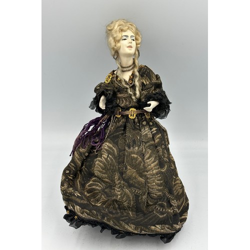 1100 - A 19thC doll with bisque head and arms on a weighted base. 32cm h.