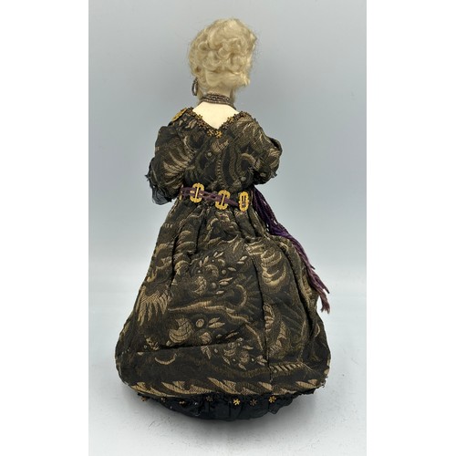 1100 - A 19thC doll with bisque head and arms on a weighted base. 32cm h.