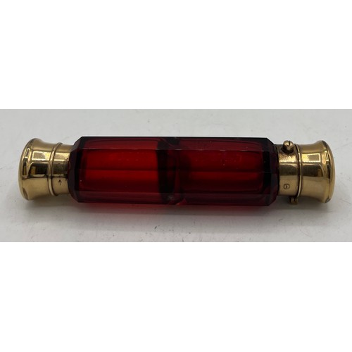 1290 - A 19thC ruby glass double ended scent bottle with gild caps. 11.5cm l.