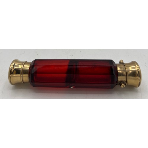 1290 - A 19thC ruby glass double ended scent bottle with gild caps. 11.5cm l.