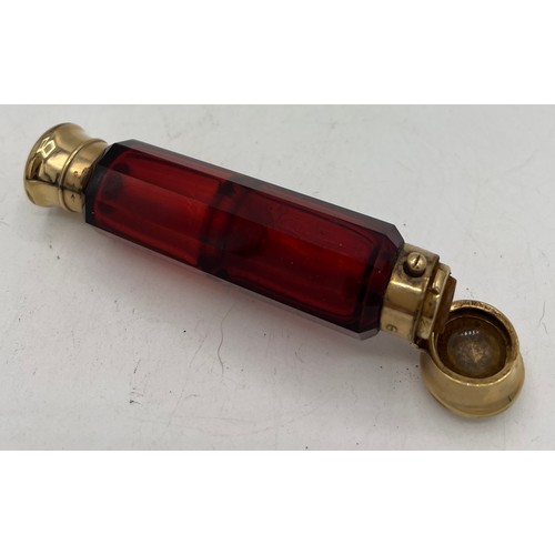 1290 - A 19thC ruby glass double ended scent bottle with gild caps. 11.5cm l.