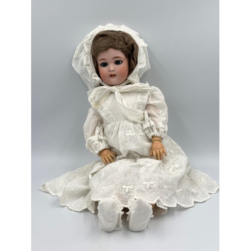 1074 - A German porcelain head doll by Simon & Halbig. Marked S & H 10 with blue sleeping eyes, light brown... 