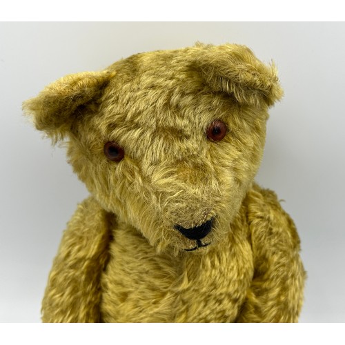 1077 - An early 20thC straw filled Teddy with glass amber eyes black stitched nose, mouth and claws, swivel... 