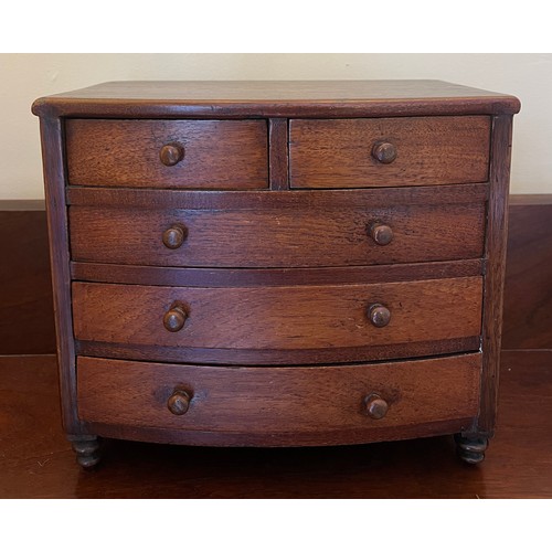 1285 - A 19thC miniature mahogany bow fronted chest of drawers with 2 short over 3 long drawers and turned ... 