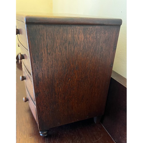 1285 - A 19thC miniature mahogany bow fronted chest of drawers with 2 short over 3 long drawers and turned ... 