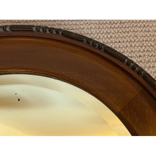 1227 - A mahogany circular bevel edged wall mirror. 47cm d.