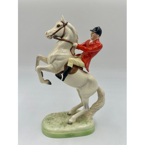 208 - Beswick model of Huntsman on rearing horse, no. 868, together with three Beswick hounds.