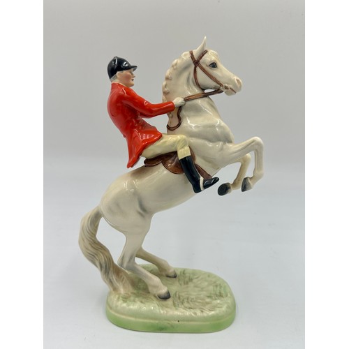 208 - Beswick model of Huntsman on rearing horse, no. 868, together with three Beswick hounds.