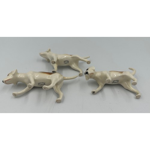 208 - Beswick model of Huntsman on rearing horse, no. 868, together with three Beswick hounds.