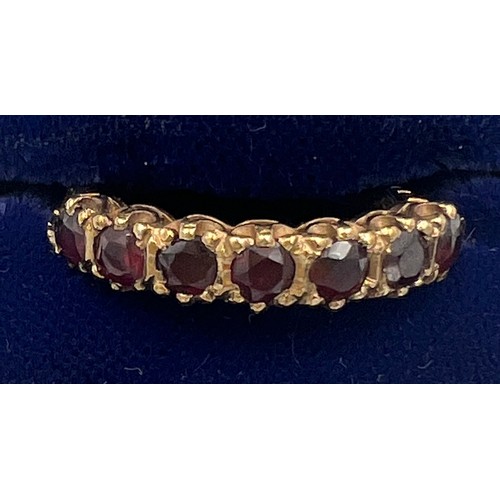 370 - A nine carat gold ring set with seven garnets. Size P. Weight 2.7gm.