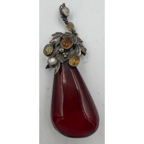 375 - White metal mounted cherry amber drop pendant the mount set with gems to include moonstones. Weight ... 