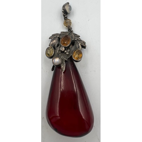 375 - White metal mounted cherry amber drop pendant the mount set with gems to include moonstones. Weight ... 