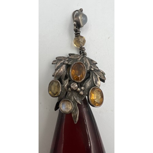 375 - White metal mounted cherry amber drop pendant the mount set with gems to include moonstones. Weight ... 